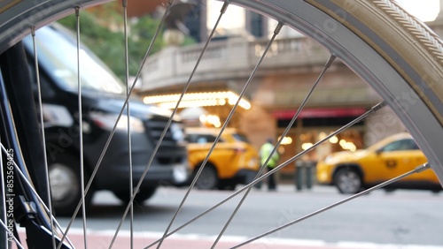 New York City Grand Central Terminal railway station, 42 street. Manhattan Midtown. Yellow taxi cabs, car transport on Pershing Square, NYC, USA. American urban road traffic, people thru bike wheel.
