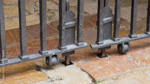 Wallpaper Mural Ancient wrought iron gate stoppers with rollers on an antique aged weathered exterior floor close up Torontodigital.ca