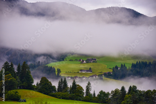 Morning mist rising over Alpine valley in autumn colorful countryside
 photo