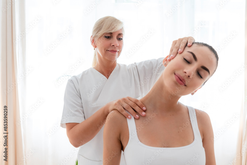Physiotherapist examining neck of patient with pain in hospital Physiotherapist examining neck of patient with pain in hospital