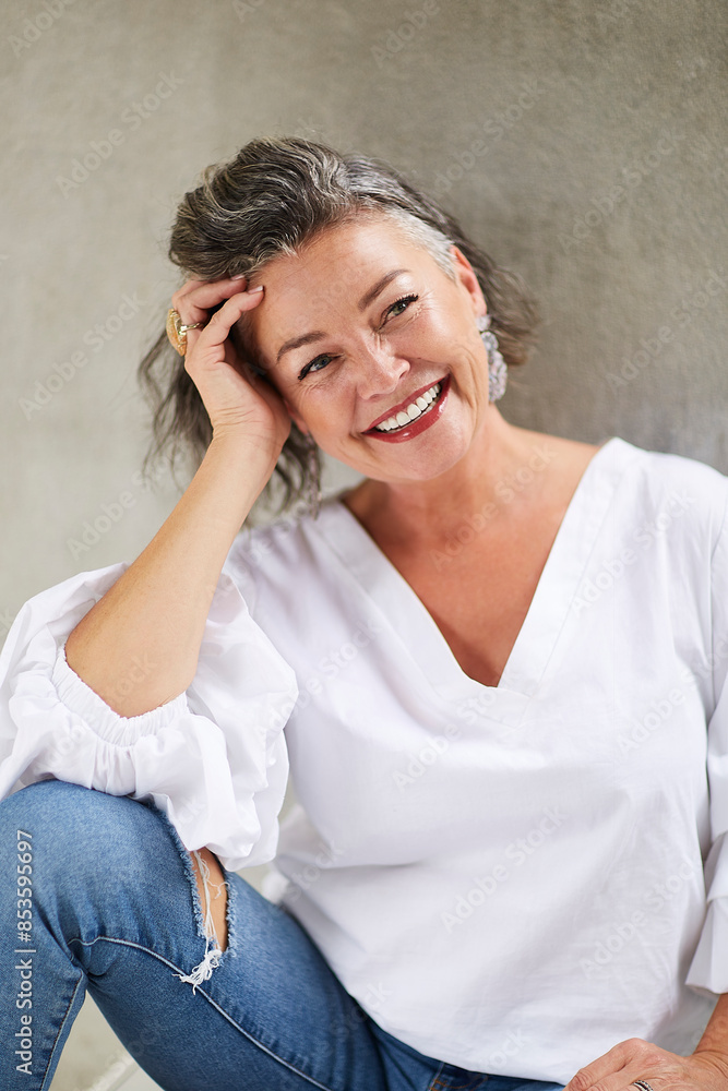 Happy beautiful woman sitting in front of wall Happy beautiful woman sitting in front of wall