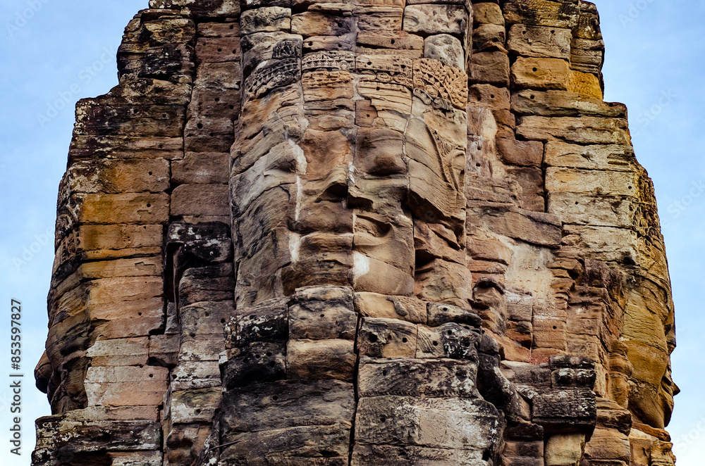 Fototapeta premium The bayon temple smiling stone faces showing on a sunny day in angkor thom, siem reap, cambodia