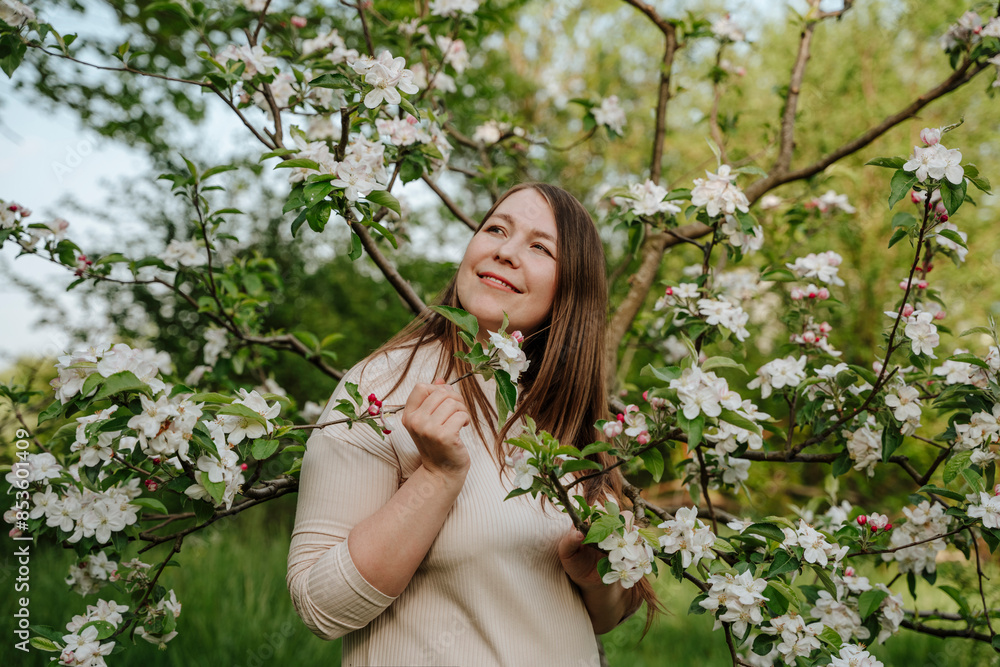 Thoughtful woman standing between apple blossom tree at farm Thoughtful woman standing between apple blossom tree at farm