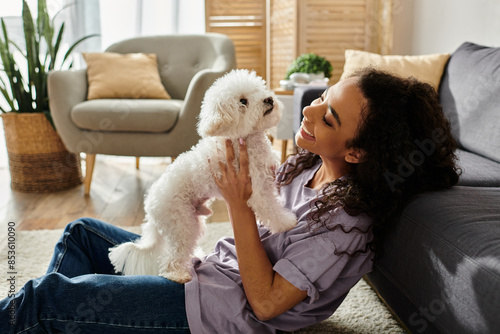Woman peacefully holding her white dog on a cozy couch.