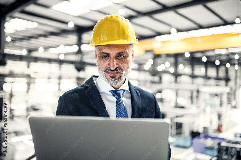 Portrait of project manager standing in modern industrial factory, holding tablet. Manufacturing facility with robotics, robotic arms and automation. Storing products and materials in warehouse. Portrait of project manager standing in modern industrial factory, holding tablet. Manufacturing facility with robotics, robotic arms and automation. Storing products and materials in warehouse.