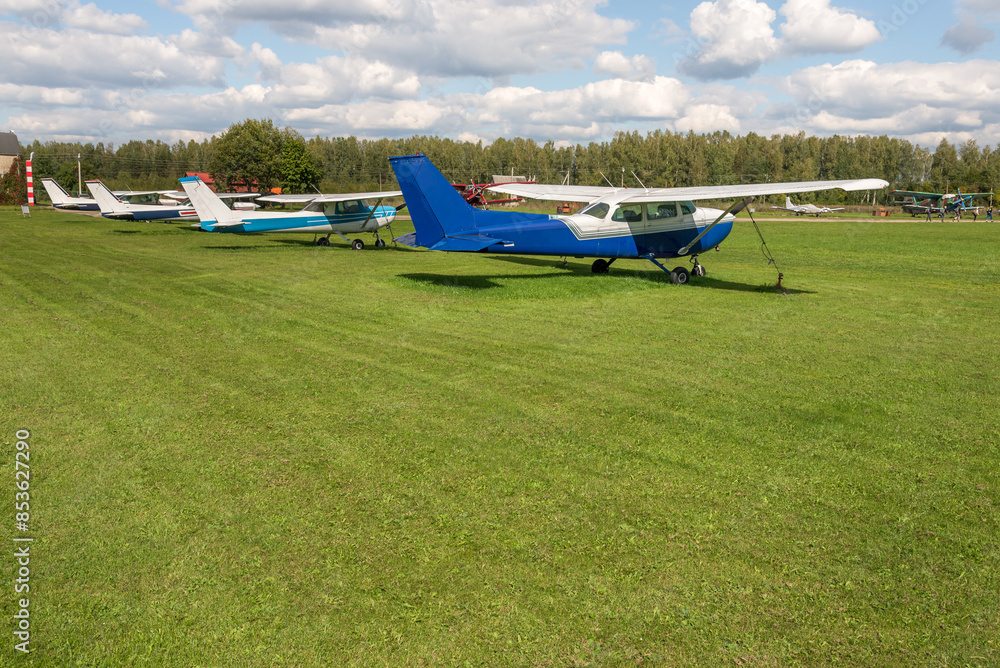 Aerobatic Airplanes Standing On Green Grass In Small Airport Aerobatic Airplanes Standing On Green Grass In Small Airport