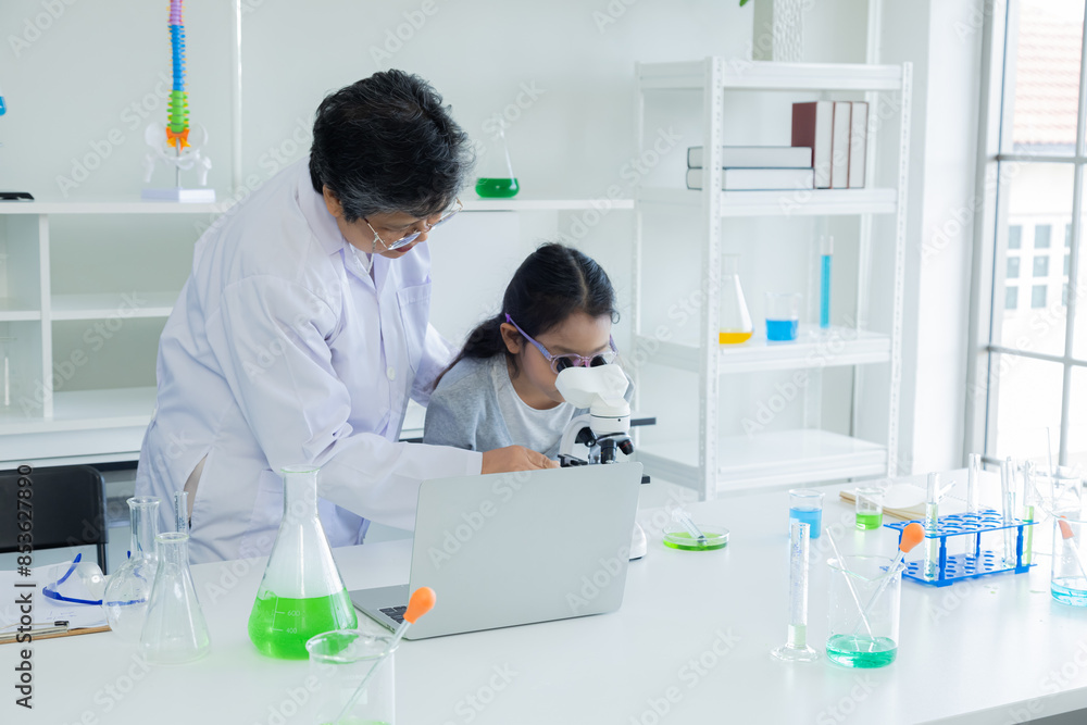 Senior teacher woman demonstrating microscope experiment to students in science class observing and learning. lab equipment, tubes and chemical solutions visible, education concept back to school Senior teacher woman demonstrating microscope experiment to students in science class observing and learning. lab equipment, tubes and chemical solutions visible, education concept back to school
