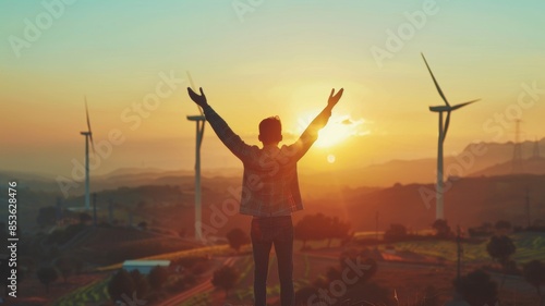 Person Celebrating at Wind Farm Sunset 