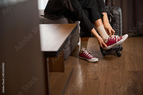 Woman sitting on a sofa and takes off her shoes