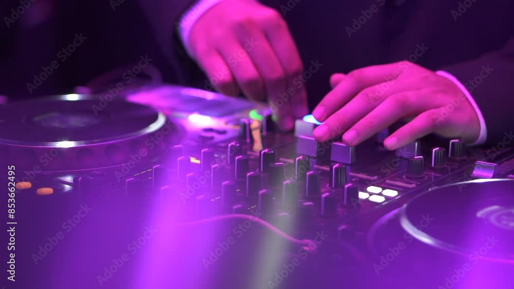Hands Of Dj Moving Controls On Record Deck In Night Club, up close Hands Of Dj Moving Controls On Record Deck In Night Club, up close