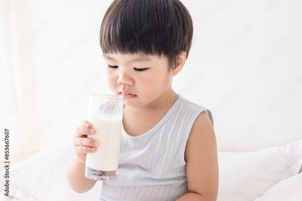 A Chinese little girl drinking milk in bedroom A Chinese little girl drinking milk in bedroom