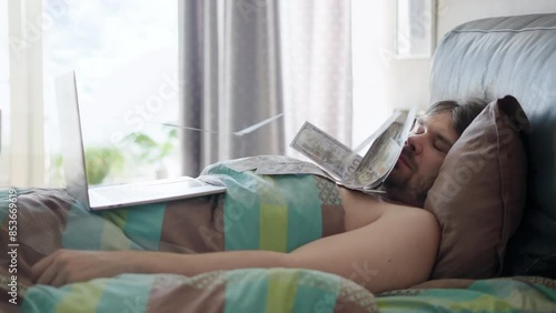 Man making money online while sleeping. Man awakening from sleep by a flow of money flying from laptop. Making money from comfort of bed. Lazy man passive income while sleep concept. Investing
