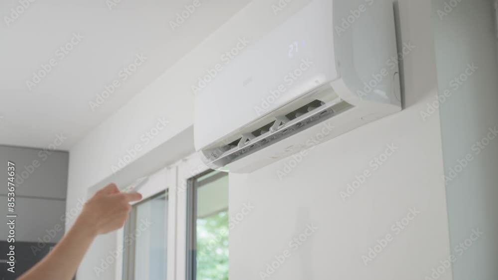 Air conditioner mounted on white wall in modern apartment. Cooling system for comfortable temperature in living room Air conditioner mounted on white wall in modern apartment. Cooling system for comfortable temperature in living room
