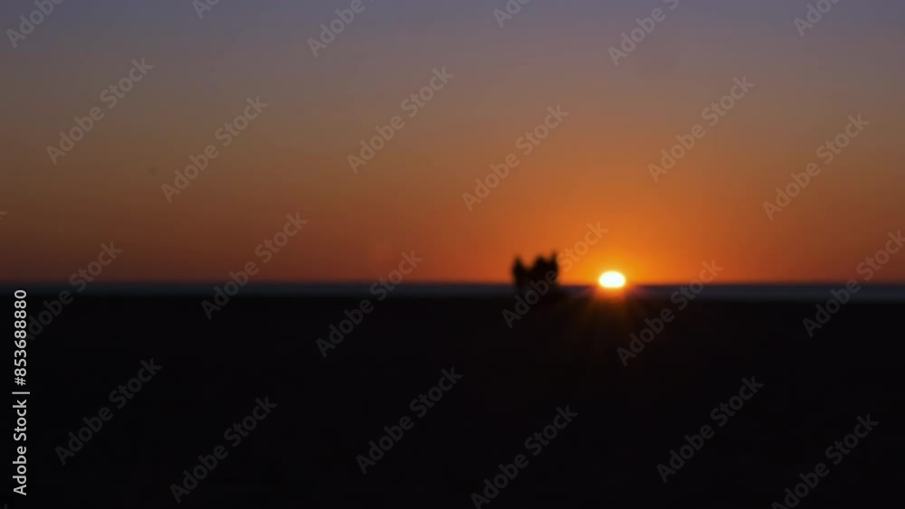 Blurred, out of focus timelapse speed video of a group of people heading towards the sunset. Golden hour, yellow, red vibrant sun and sky. A dark silhouette quickly walks around at the horizon beach Blurred, out of focus timelapse speed video of a group of people heading towards the sunset. Golden hour, yellow, red vibrant sun and sky. A dark silhouette quickly walks around at the horizon beach