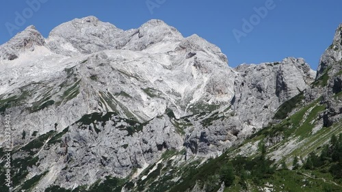 Vodnikov dom na Velem polu tourist cottage in Slovenian Julian Alps, zooming shot on Vernar peak photo