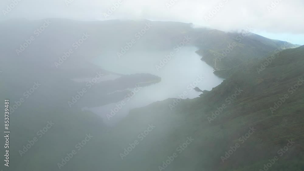 Misty aerial view of Lagoa do Fogo, an emerald lake nestled in a lush volcanic crater Misty aerial view of Lagoa do Fogo, an emerald lake nestled in a lush volcanic crater