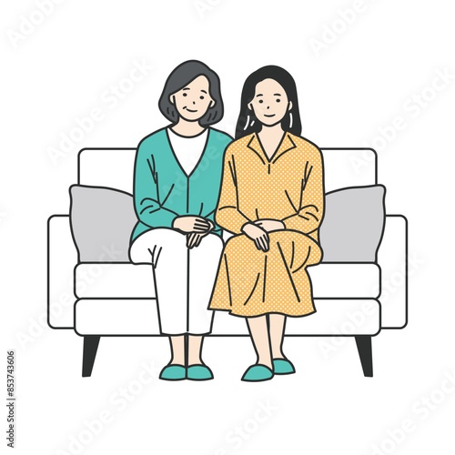 ソファに座るシニア女性と若い女性の家族