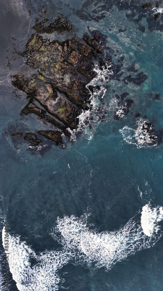 Rock formations in the sea on a coast covered with black sand Rock formations in the sea on a coast covered with black sand