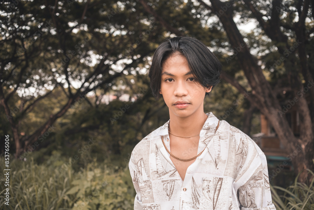 Young man in boho fashion standing outdoors in nature Young man in boho fashion standing outdoors in nature