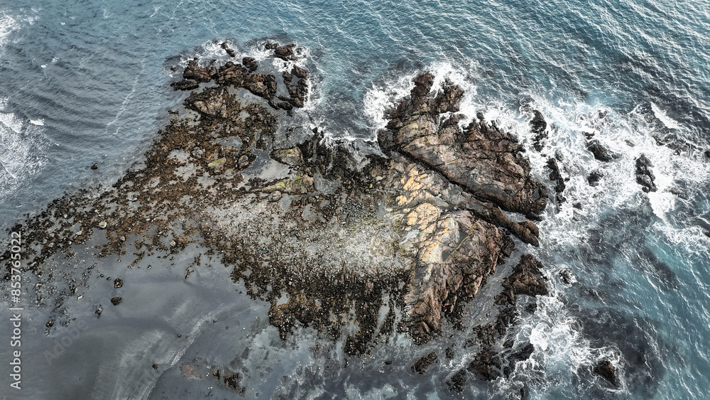 Rock formations in the sea on a coast covered with black sand Rock formations in the sea on a coast covered with black sand