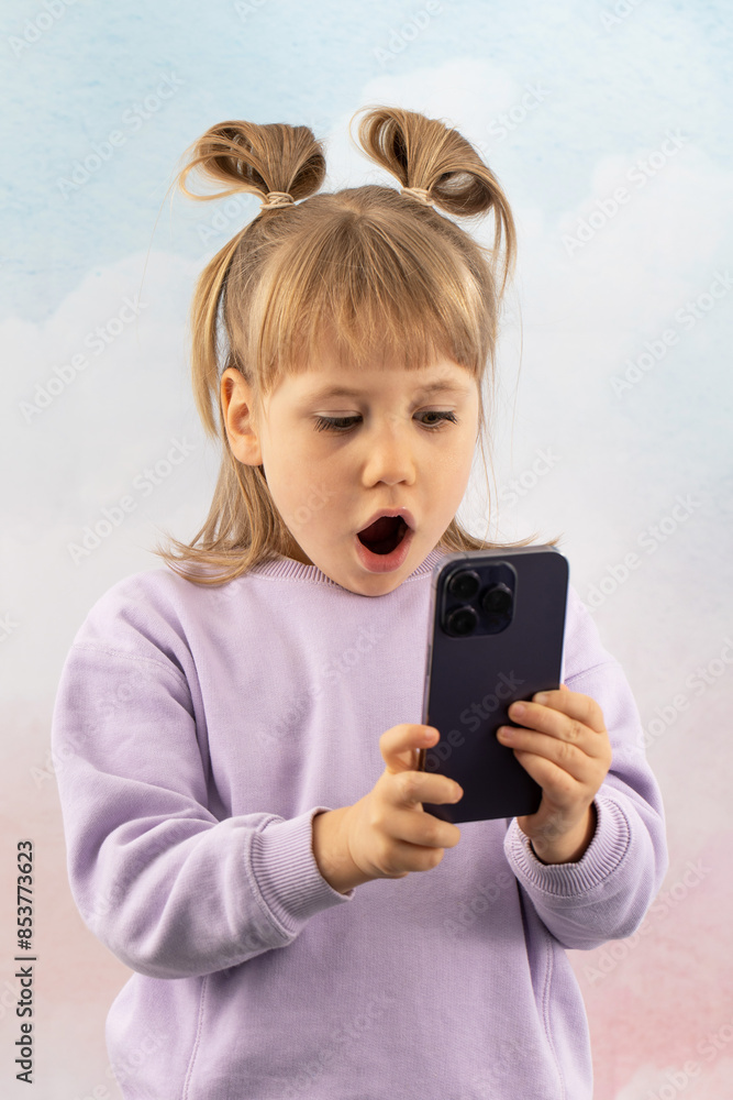 Shocked junior schoolgirl stares at phone screen gaping mouth Shocked junior schoolgirl stares at phone screen gaping mouth