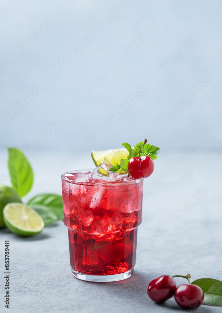 Cherry-lime mojito cocktail with mint, lime and ice on a blue background with fresh berries. Cherry-lime mojito cocktail with mint, lime and ice on a blue background with fresh berries.