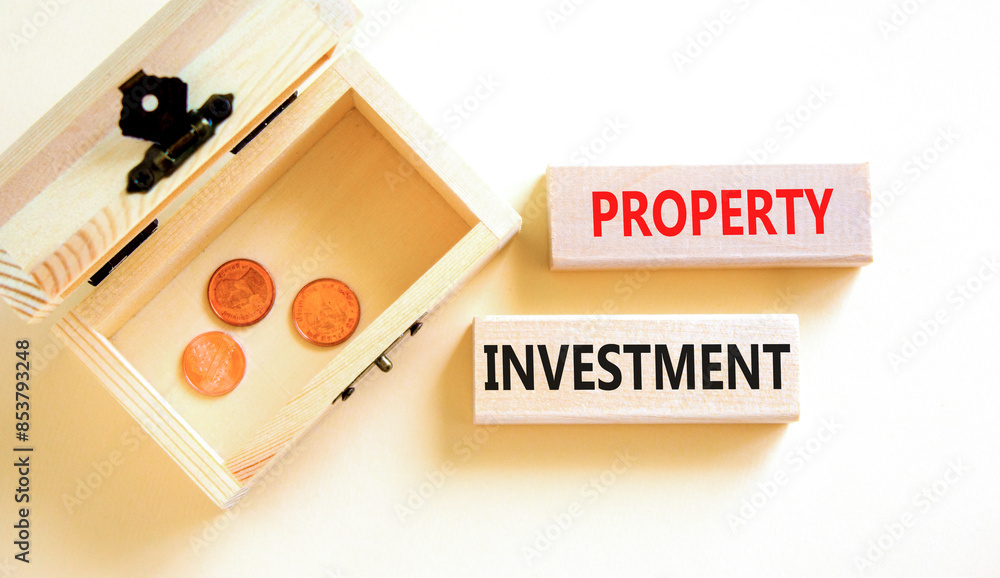 Property investment symbol. Concept words Property investment on beautiful wooden block. Beautiful white paper background. Wooden chest with coins. Business Property investment concept. Copy space. Property investment symbol. Concept words Property investment on beautiful wooden block. Beautiful white paper background. Wooden chest with coins. Business Property investment concept. Copy space.