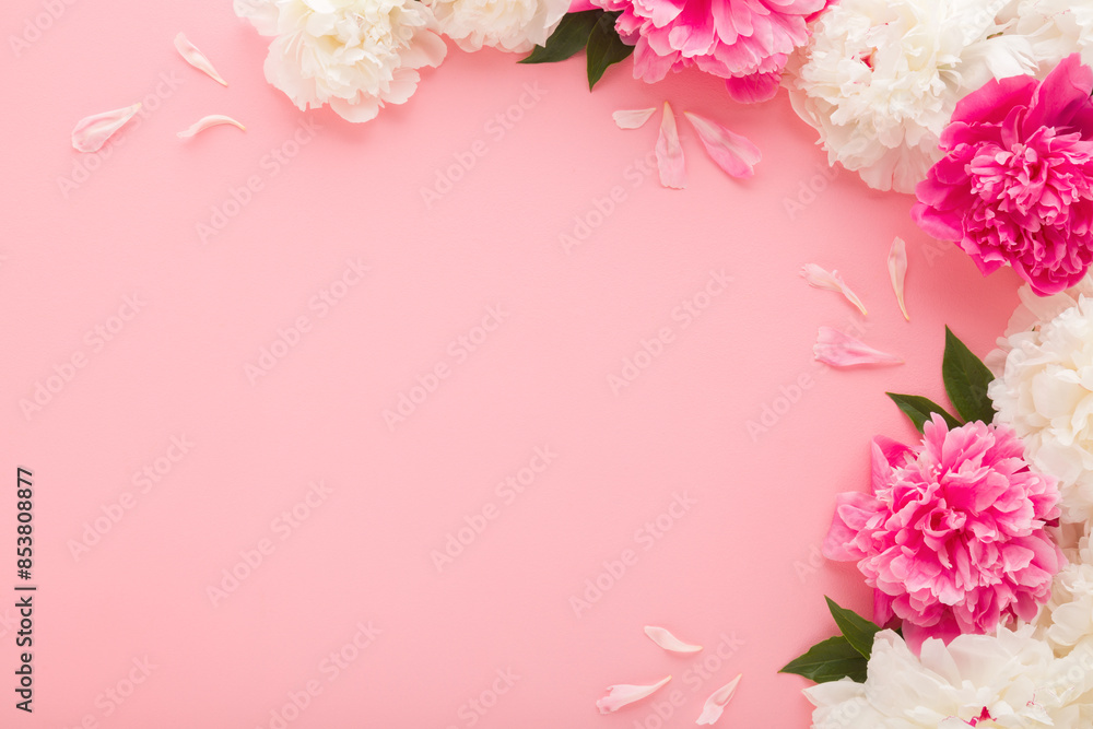 Fresh beautiful soft white pink peony flowers with green leaves on pink table background. Pastel color. Closeup. Empty place for inspirational text, lovely quote or positive sayings. Top down view.