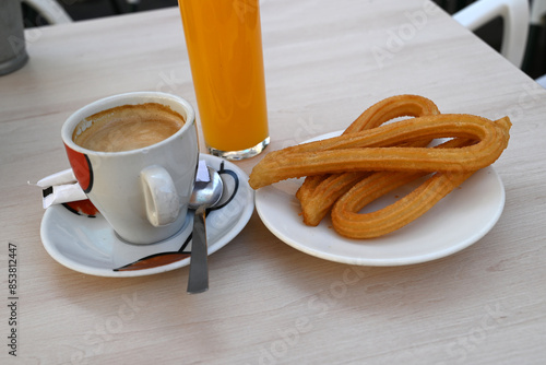 Petit déjeuner espagnol avec churros,jus d'orange et tasse de café au lait