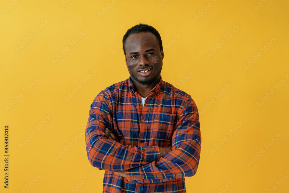 Standing and posing. Black man is in the studio against yellow background Standing and posing. Black man is in the studio against yellow background