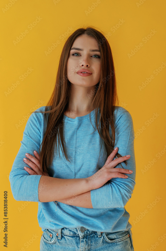 Fototapeta premium Confident look, portrait. Young woman is against yellow background