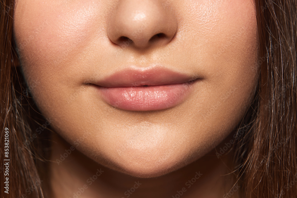 Fototapeta premium Cropped image of female face, chin, lips and nose. Perfect, smooth, well-kept skin, natural lips. Face lifting. Concept of natural beauty, skincare, cosmetology and cosmetic products ads