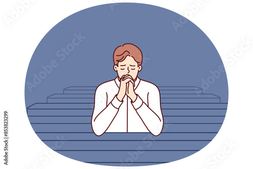 Christian man sits and prays in catholic church, turning to god to confess or ask for help. Believing guy in church and prays to feel psychological relief or observe religious ritual