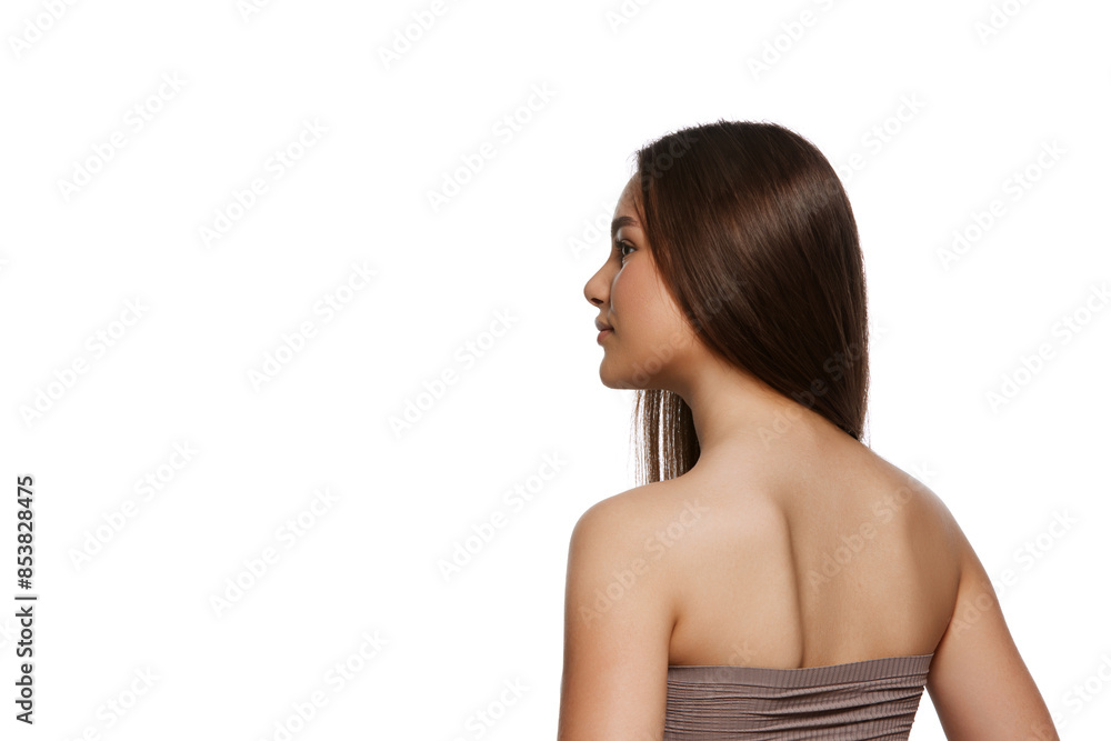 Back view image of beautiful young girl with perfect brown shiny hair and perfect well-kept skin isolated on white background. Concept of natural beauty, hair care, cosmetic products ads Back view image of beautiful young girl with perfect brown shiny hair and perfect well-kept skin isolated on white background. Concept of natural beauty, hair care, cosmetic products ads