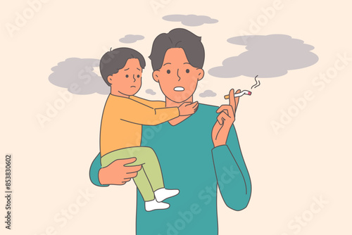 Man smokes and holds little son in arms, for concept harm of passive smoking causing cancer