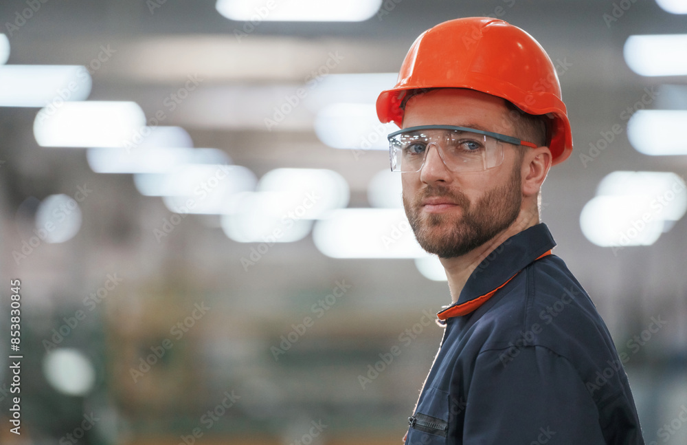 Blurred background. Factory worker is indoors with hard hat Blurred background. Factory worker is indoors with hard hat