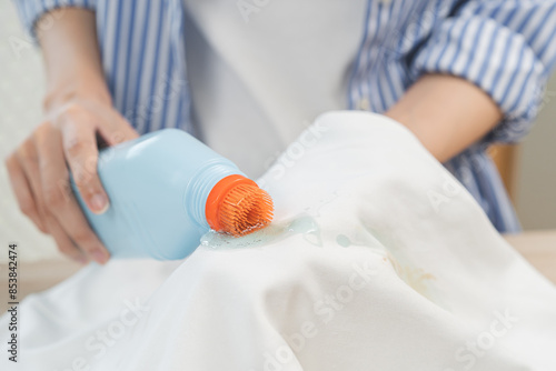 Foto Dirty stain concept, asian young housewife woman removing spill from white T-shi