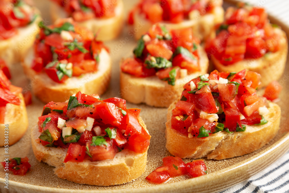 Homemade Italian Tomato Bruschetta on a Plate, side view. Close-up. Homemade Italian Tomato Bruschetta on a Plate, side view. Close-up.
