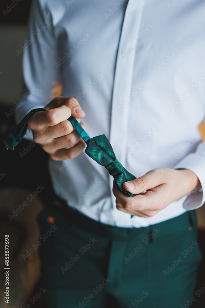 A man holds a stylish green butterfly in his hands. Bow tie for a stylish look. A man holds a stylish green butterfly in his hands. Bow tie for a stylish look.