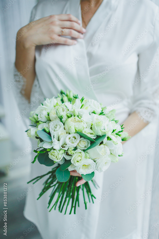 The bride in a white dress holds a bouquet of fresh flowers in her hands. Bride's bouquet. The bride in a white dress holds a bouquet of fresh flowers in her hands. Bride's bouquet.