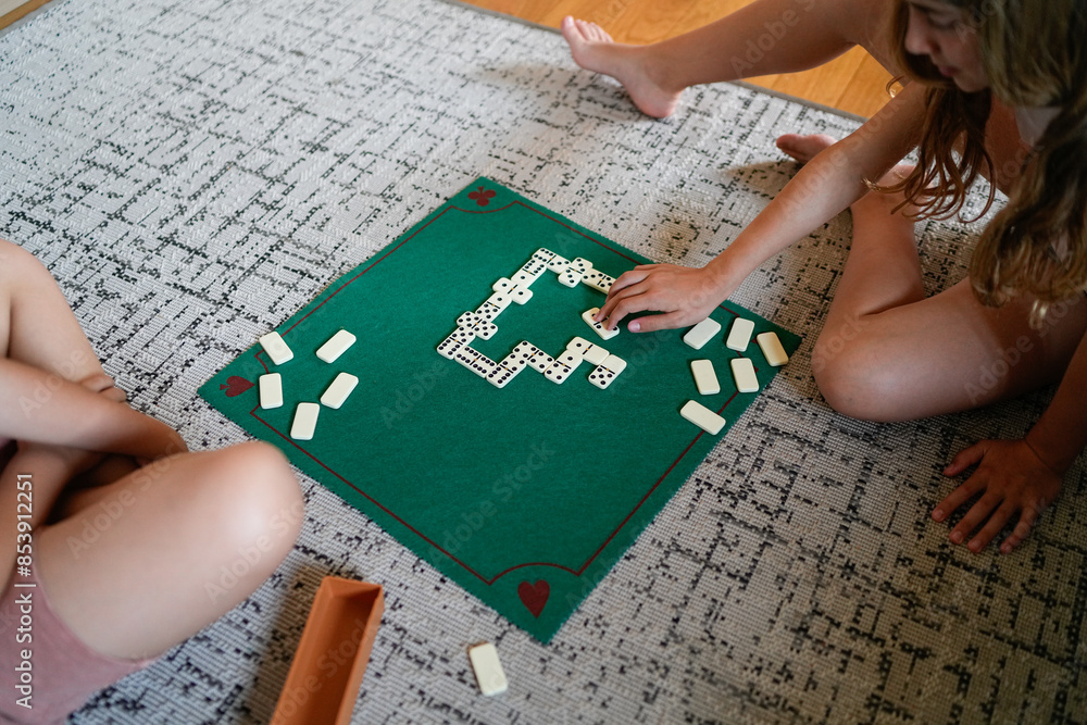 Obraz premium Two girls playing a game of dominoes