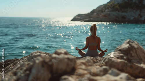 Yoga am Meer Frau sitzt an einer felsigen Küste und macht Yoga Generative AI photo