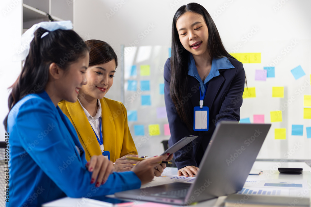 Businesswoman presenting to colleagues in conference room with charts and data Businesswoman presenting to colleagues in conference room with charts and data