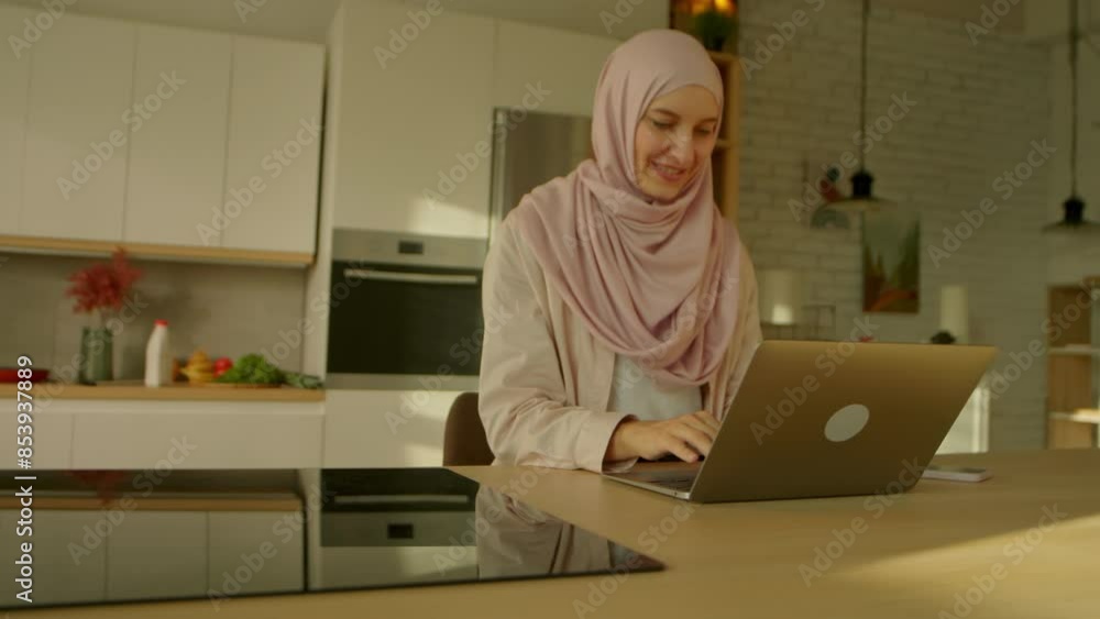 Smiling muslim business woman wearing hijab working on laptop on desk table feel happy at home. Sunlight. Camera moving around. 360 degrees Smiling muslim business woman wearing hijab working on laptop on desk table feel happy at home. Sunlight. Camera moving around. 360 degrees