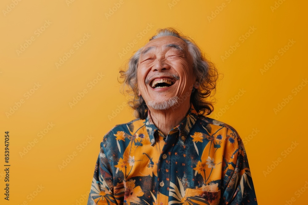 Portrait of a jovial asian man in his 70s laughing isolated on pastel yellow background Portrait of a jovial asian man in his 70s laughing isolated on pastel yellow background