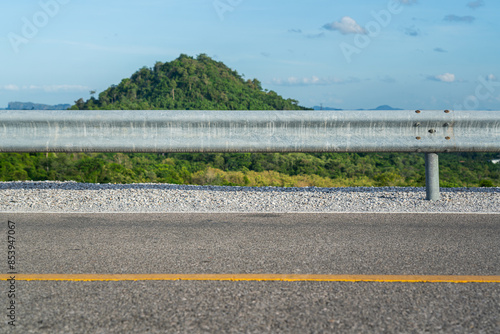 Roadside metal rail barrier structure which is installed on side of the road for protected the car accident. Transportation safety equipment object, selective focus. photo