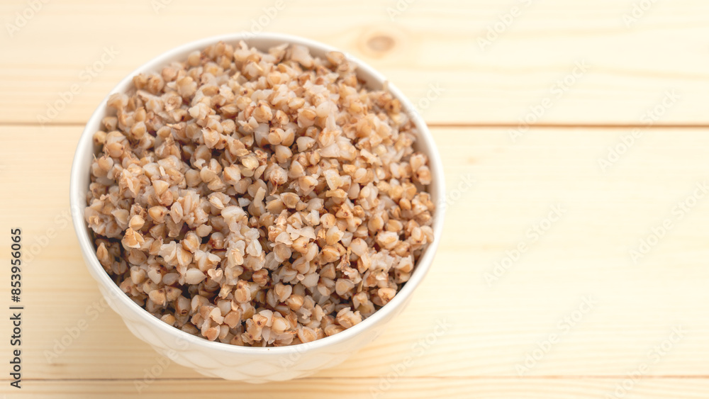 buckwheat porridge in a round white plate on a wooden table. buckwheat porridge in a round white plate on a wooden table.