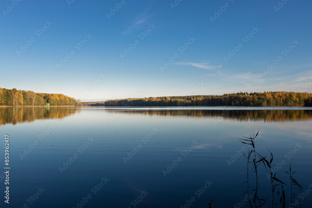 A calm lake with a blue sky in the background