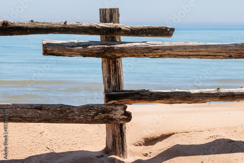 Wooden fence post with rails, part of a fence that separates the beach from the parking area at Point Beach State Foreset, Two Rivers, Wisconsin in early May photo