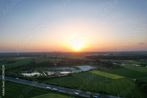 An aerial view of a sunset over a green field with a beautiful sky and clouds 5K FPV drone view Hanover Kolenfeld Germany 